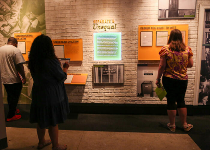 Visitors standing in front of an exhibit wall