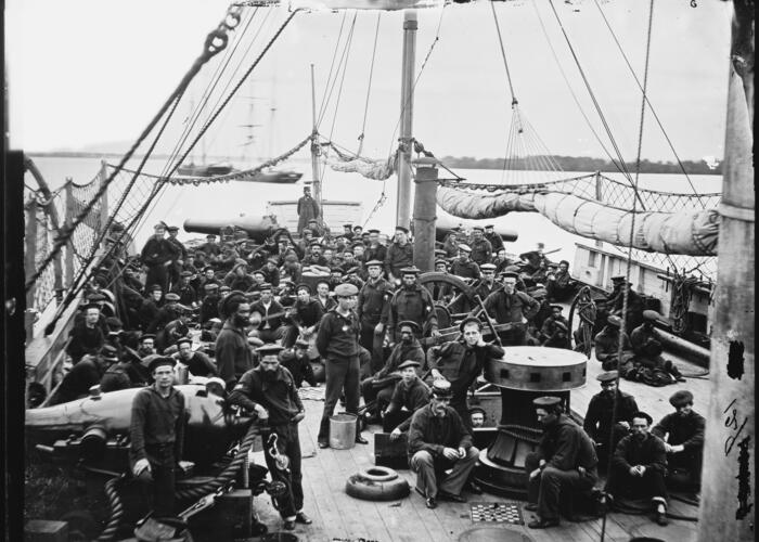 Black and white image of men standing aboard a civil war era gunboat
