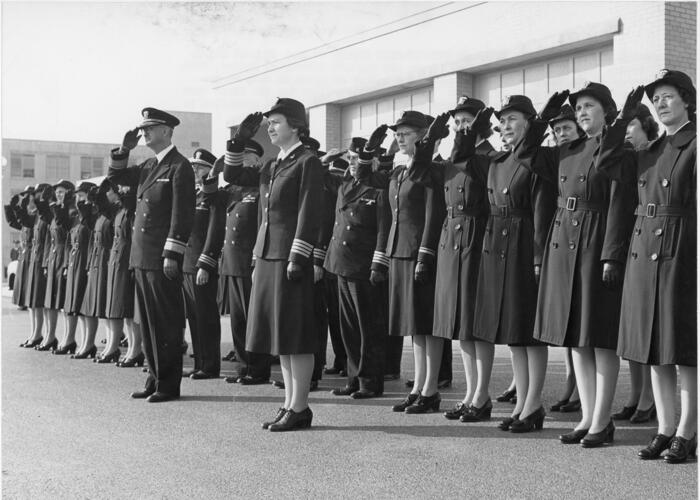 Uniformed women standing at attention and saluting