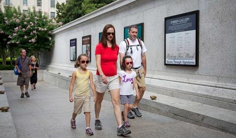 Adults and children walking into the National Archives