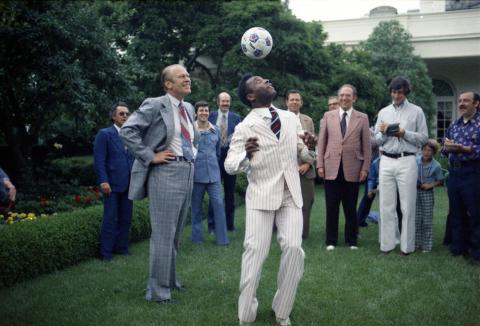 Pele juggles a soccer ball in the Rose Garden at the White House, seen with President Gerald R. Ford