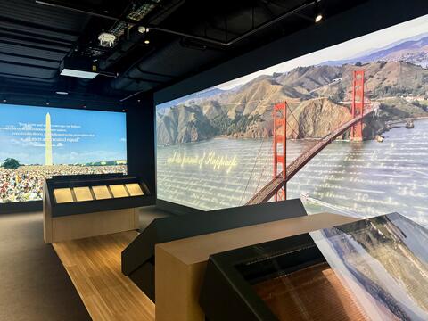 The Chartering Freedom gallery within The American Story, featuring large screens and cases featuring records like the Emancipation Proclamation and 1823 Stone Engraving Copper Plate of the Declaration of Independence