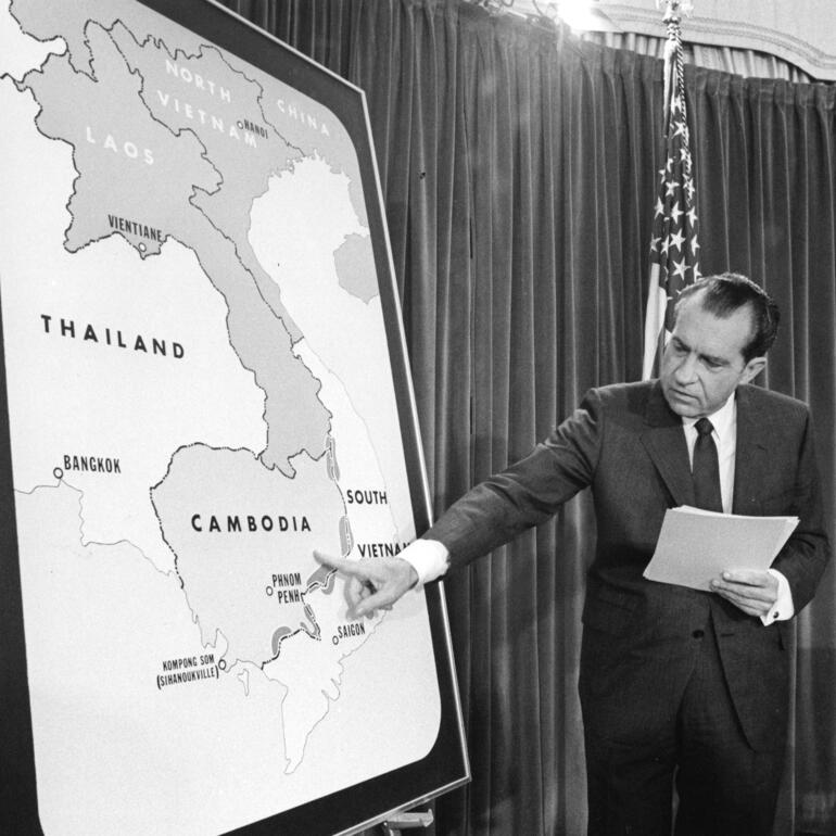 Black and white photograph of President pointing to a map of Cambodia