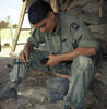 Solider cleans his M–16 rifle prior to going out on a daily patrol