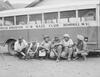 Baseball players sitting in front of a bus