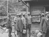 Group of miners in front of sign