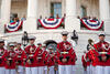 President and First Lady standing on White House balcony with soldiers standing below