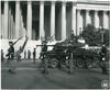 Black and white photograph of soldiers marching with a tank in front of the National Archives building