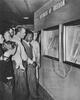 Black and white photograph of a group of people viewing a document on the Freedom Train