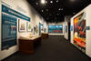 Color photograph of exhibit gallery with exhibit cases on left and imagery on right