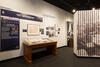 Color photograph of exhibit gallery with case and images