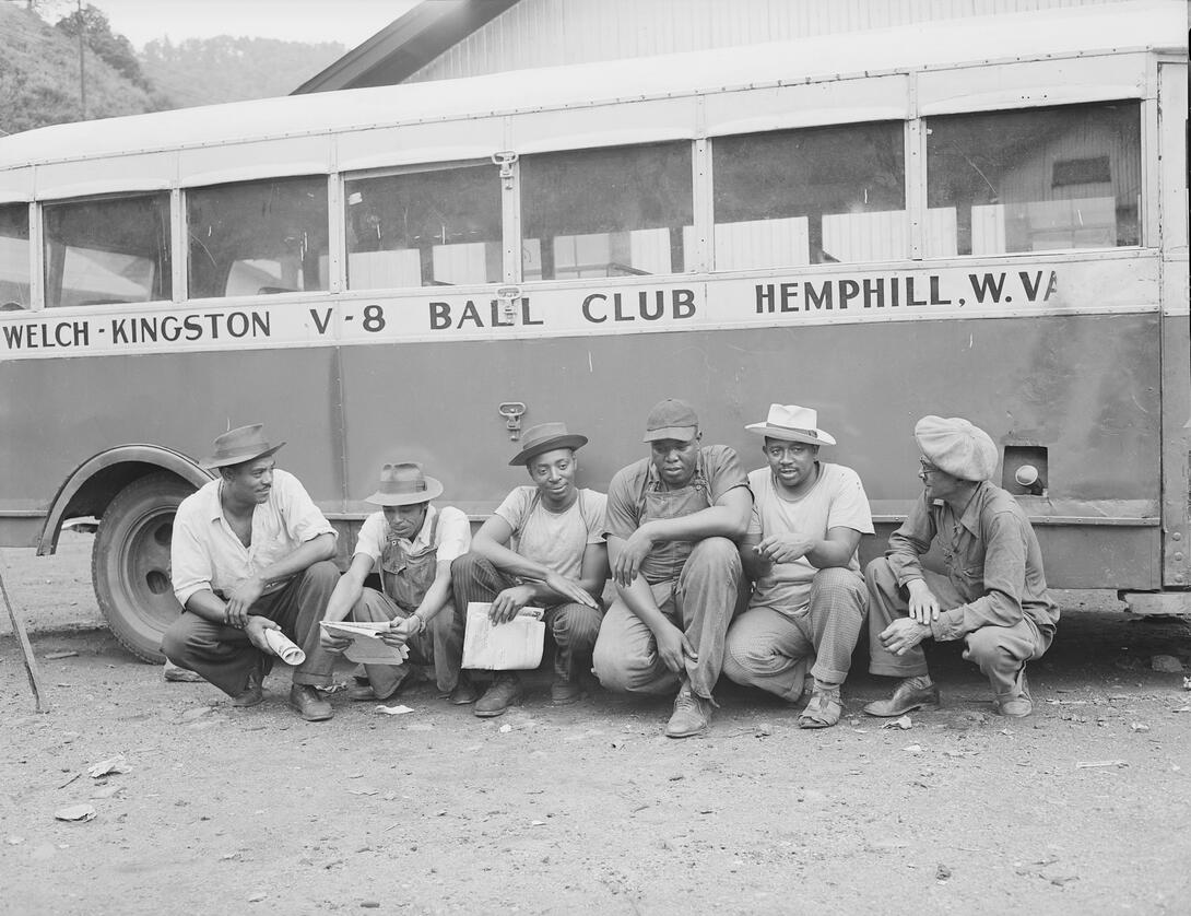 Baseball players sitting in front of a bus