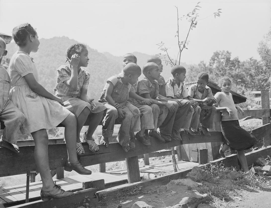 Children sitting on fence