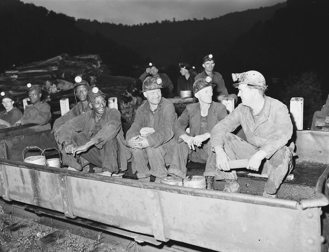 Men in a coal shuttle car