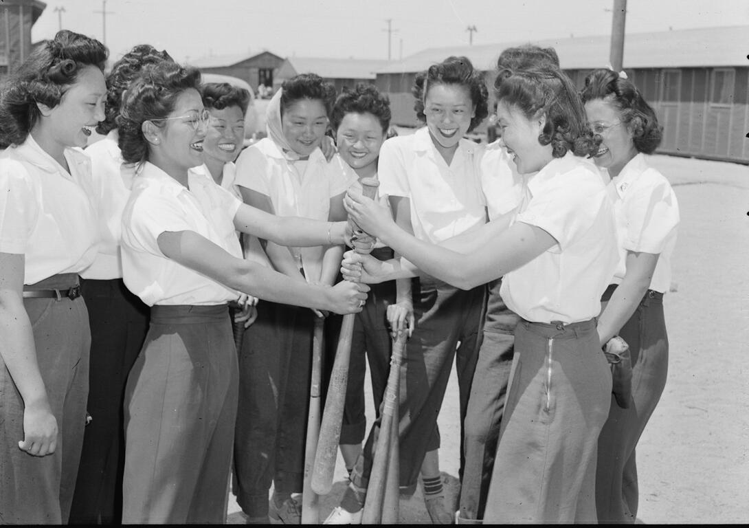 Black and white photograph of a group of women holding baseball bats