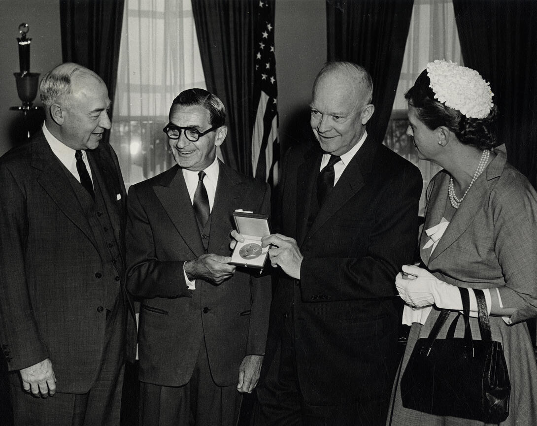 Black and white photograph of three men and a woman at a medal ceremony