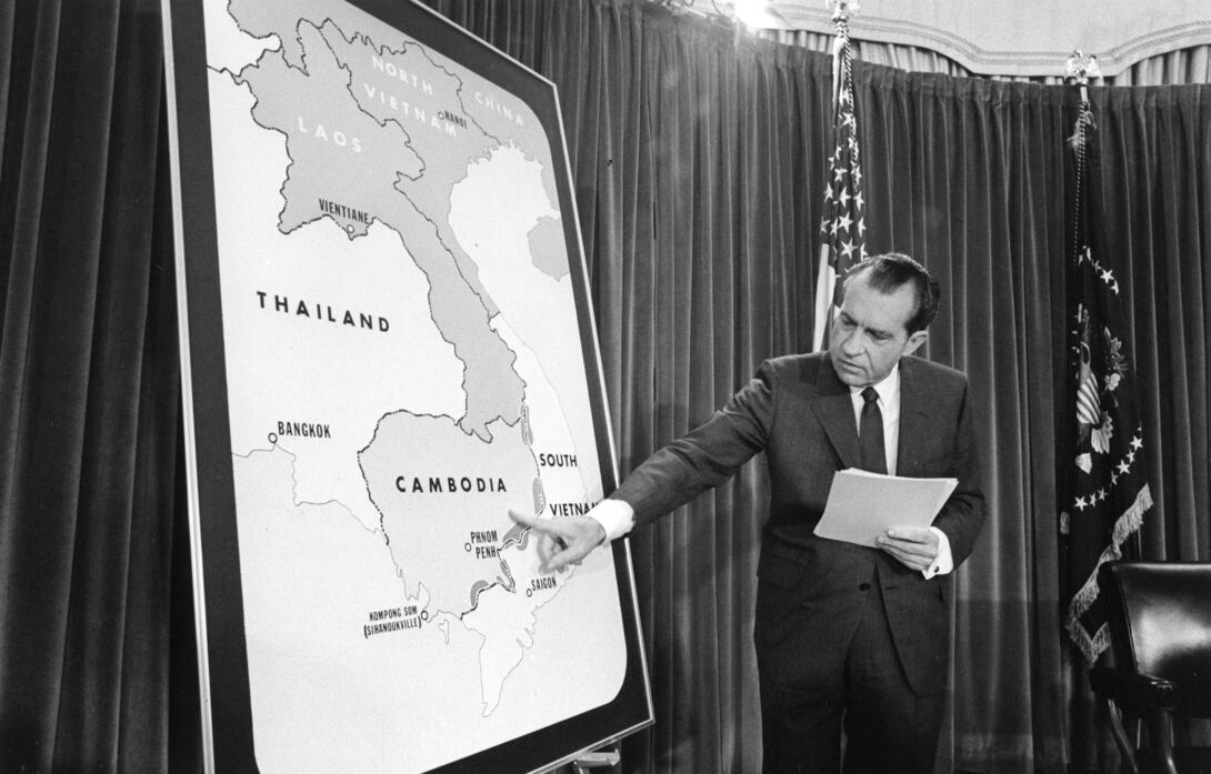 Black and white photograph of President pointing to a map of Cambodia