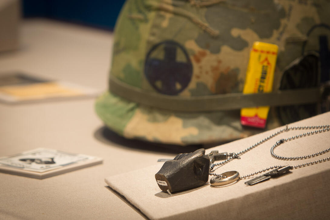 Color photograph of exhibit case with helmet and dog tabs