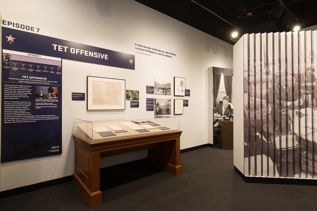 Color photograph of exhibit gallery with case and images