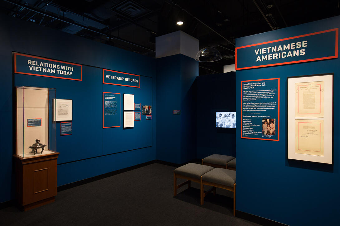 Color photograph of exhibit gallery with cases, text labels, and benches